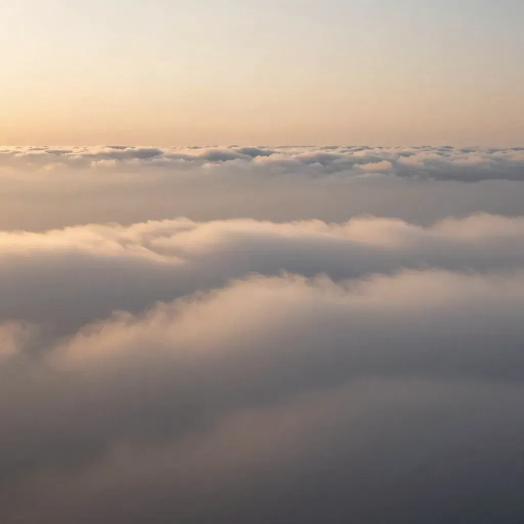 High-altitude cloud sea with a thin horizon and a faint sunrise glow